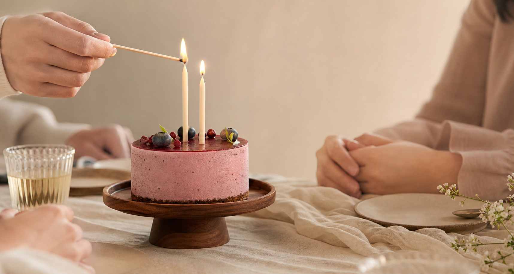 朋友圍着莓果慕絲凍餅點起生日蠟燭